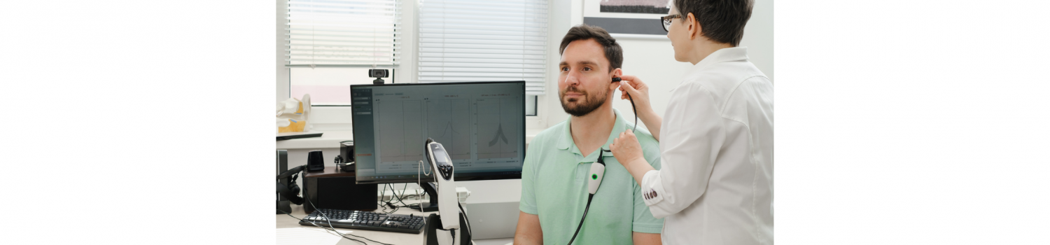 Audiologist performs a hearing exam on a middle-aged man