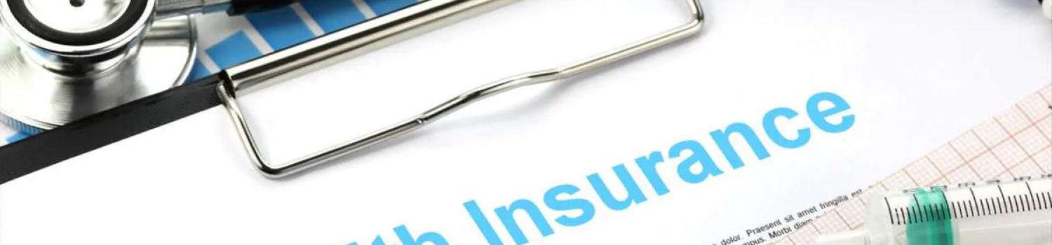 "health insurance" written at top of paper on clipboard surrounded by stethoscope and other medical instruments