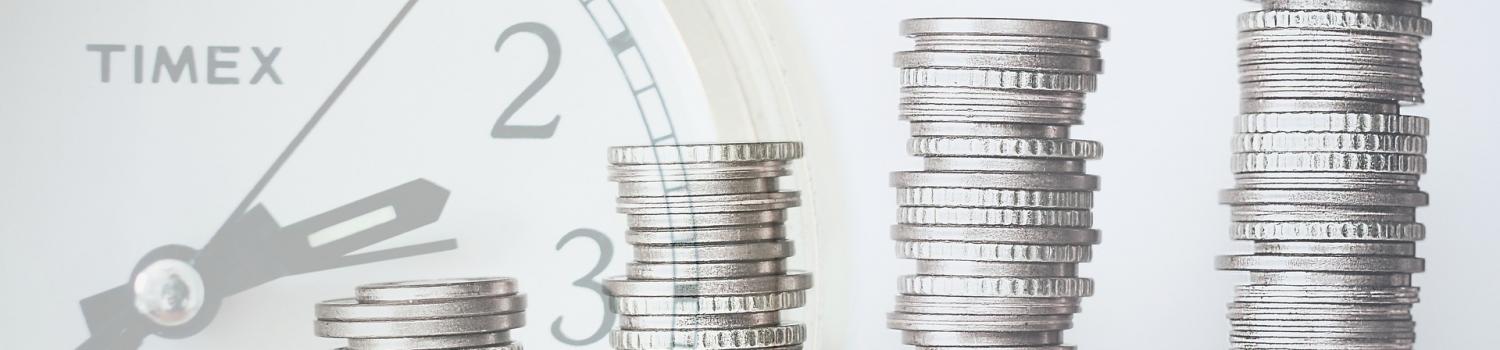 a stack of coins with an image of a clock in the background