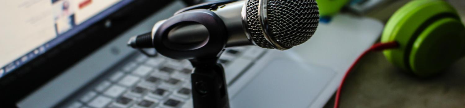 photo of microphone on stand with laptop next to it