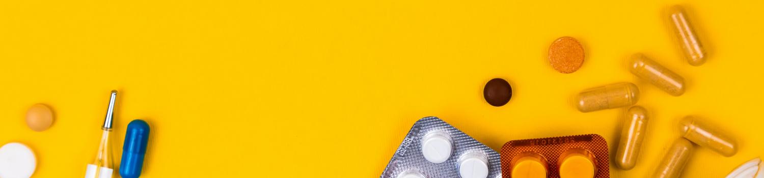a pile of pills on top of a light blue face mask on a yellow background