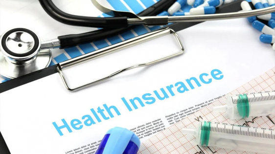 "health insurance" written at top of paper on clipboard surrounded by stethoscope and other medical instruments