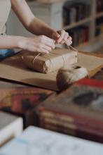 picture of woman wrapping book in brown paper